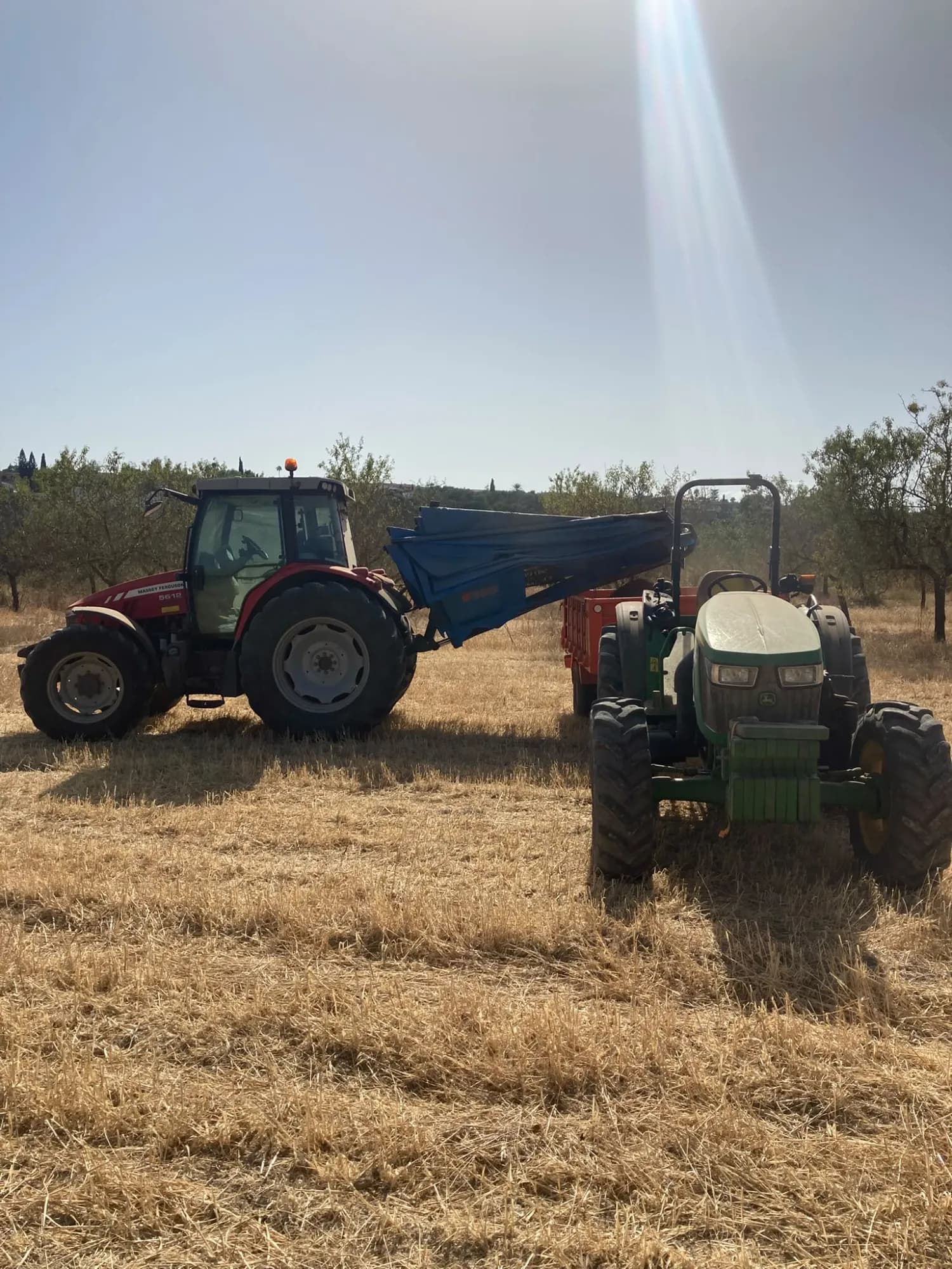 Tractores Massey Ferguson y John Deere con remolque en una finca de Mallorca